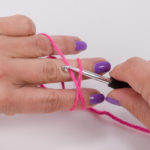 Push the crochet hook under the thread at the bottom and hook the thread at the top with the crochet hook.